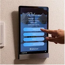 壁に設置されたタブレット端末を指で操作する様子