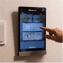 壁に設置されたタブレット端末でチェックイン操作をする様子