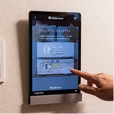 壁に設置されたタブレット端末でチェックアウトを選択する様子