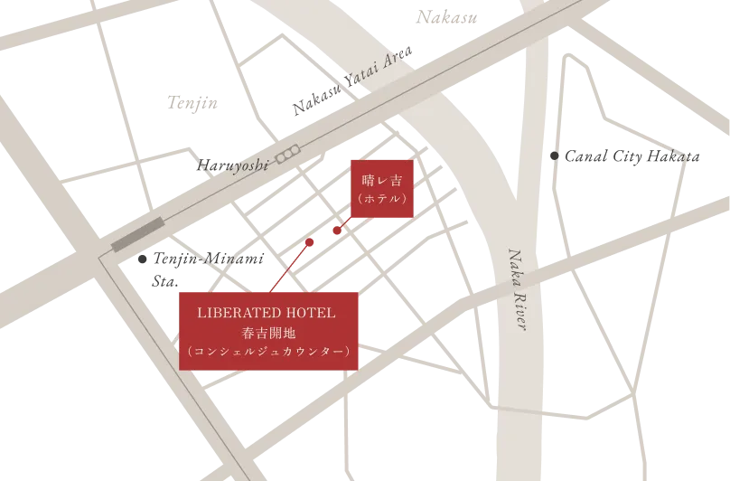 LIBERATED HOTEL (コンシェルジュカウンター) へのアクセス地図。 中央に「LIBERATED HOTEL (コンシェルジュカウンター)」の場所が赤い四角形で示されています。その右斜め上にある「晴レ吉 (ホテル)」と、赤い破線で移動経路が接続されています。地図の左側には「Nakayoshi」という駅のような施設があり、右側には「Naka River」が流れています。