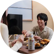 ダイニングテーブルを囲んで会話する人々。くつろぎながら食事を楽しむシーン。