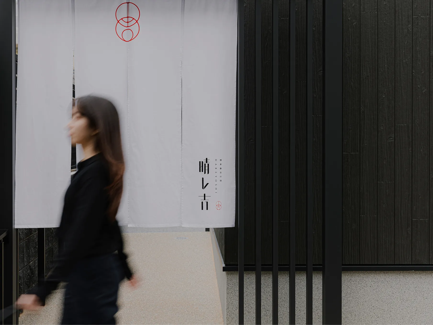 女性が晴レ吉の入口前を通る様子 