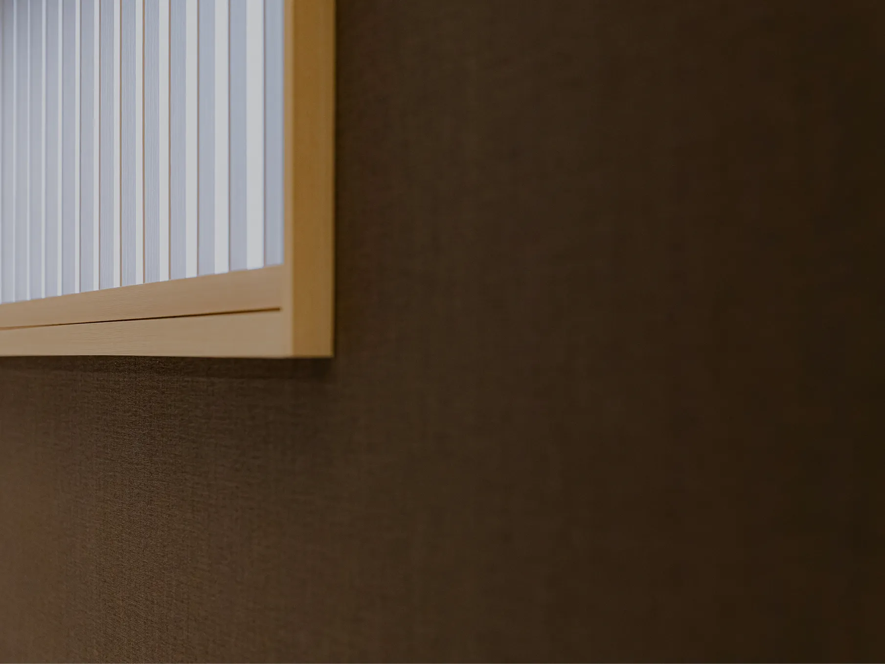 落ち着いた雰囲気のお部屋の茶色の壁と和風な窓枠