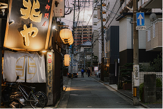 夜の路地に並ぶ飲食店の外観と提灯が灯る街並みの写真