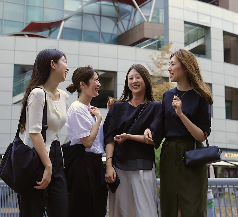 街中で会話を楽しむ女性たち。ショッピングや観光を楽しむシーン。