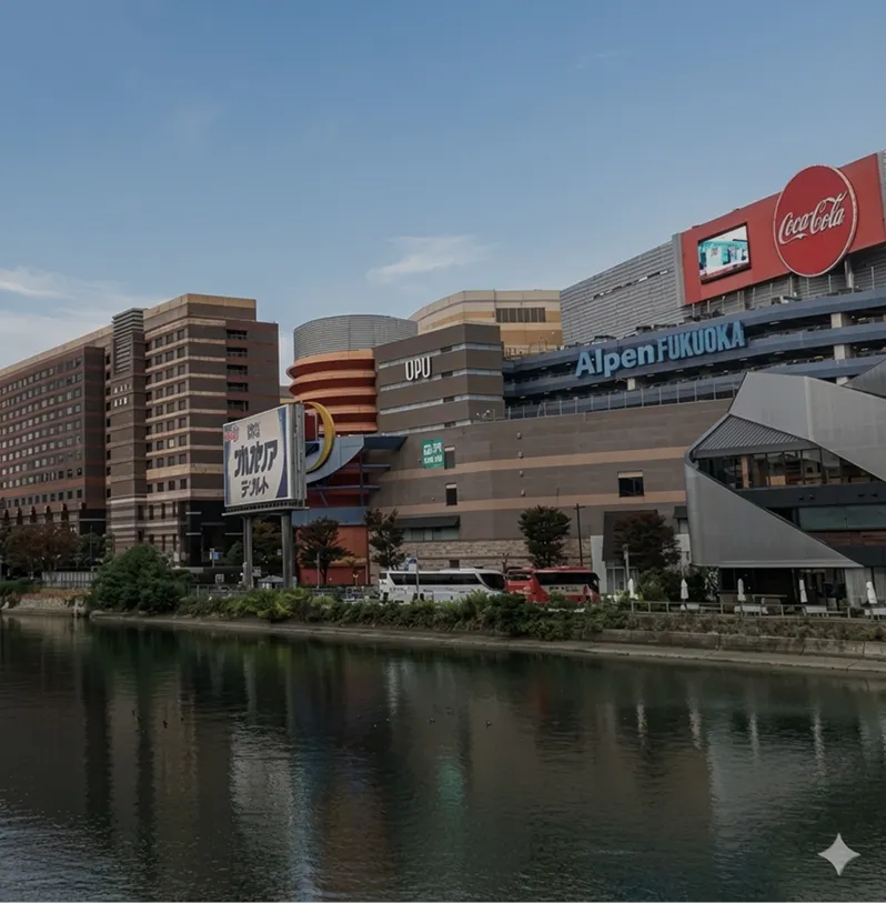 川越しに臨む、キャナルシティ博多周辺の商業施設やビル群。