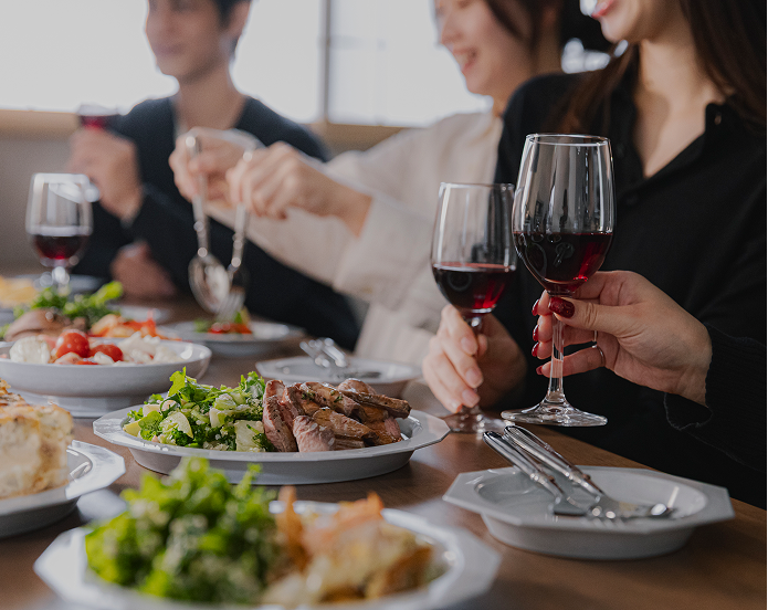 ワインを片手に食事を楽しむ人々