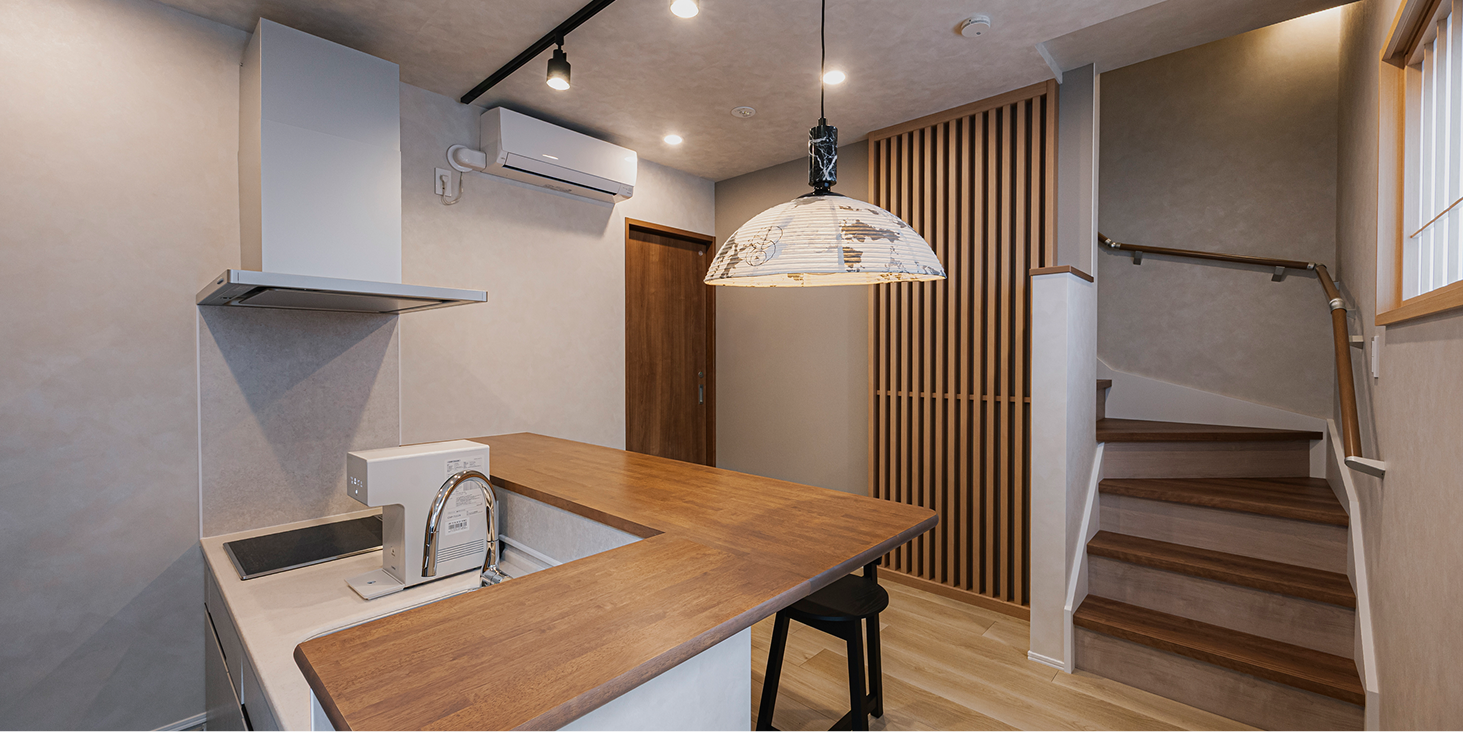 システムキッチンに、奥には2階への階段がある1階キッチン